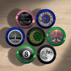 Puede incluir: Siete espejos compactos redondos, coloridos, decorativos, de metal, con forma de moneda, con varios diseños. Los diseños incluyen un árbol de la vida, una luna y estrellas, un árbol con un arcoíris, una esfera de reloj, una bola de billar 8 y una luna. Un espejo tiene el texto "Xaddy (xædɪ) noun Xaden Riordon Save a dragon. Ride a Wingleader."