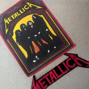 Puede incluir: Dos parches de Metallica. Un parche rectangular presenta el nombre de la banda en amarillo y una silueta de los miembros. El segundo parche es una flecha roja y negra con el nombre de la banda en rojo.