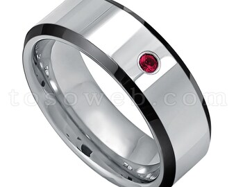 May include: A silver and black tungsten carbide ring with a single red gemstone set in the center.