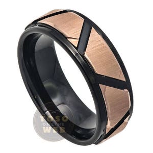 Puede incluir: Un anillo de carburo de tungsteno negro y oro rosa con un diseño geométrico. El anillo tiene un acabado cepillado y un borde biselado.