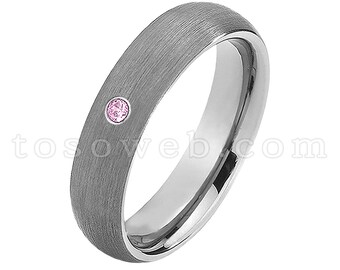 Pode incluir: Uma aliança de prata escovada com uma única gema rosa engastada na banda.