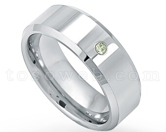 May include: A silver wedding band with a single, small, light green gemstone set in the center.