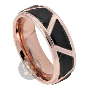 Puede incluir: Una banda de boda de oro rosa y negro con un diseño geométrico. La banda está hecha de carburo de tungsteno y tiene un acabado cepillado.