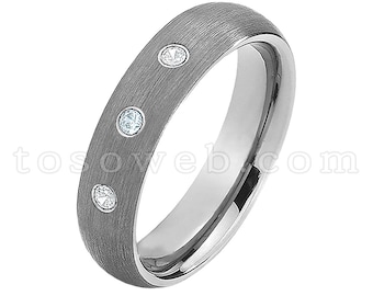 Pode incluir: Uma aliança de prata escovada com três pequenos diamantes cravejados na banda.