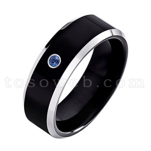 May include: A black tungsten carbide ring with a silver band and a blue gemstone.