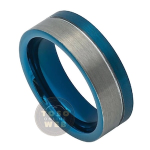 Puede incluir: Un anillo de carburo de tungsteno azul y plateado con acabado cepillado. El anillo tiene una banda ancha con una incrustación plateada.