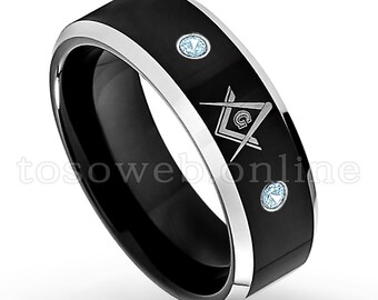 May include: A black and silver tungsten carbide ring with a silver Masonic symbol and three blue gemstones.