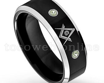 May include: Black tungsten carbide ring with a silver Masonic symbol and two green gemstones.