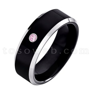 May include: A black tungsten carbide ring with a silver band and a pink gemstone. The ring is a classic style and would make a great gift for a special occasion.