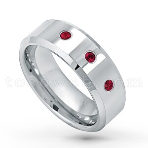 May include: A silver band with three red gemstones set into the metal. The band is beveled and has a polished finish.