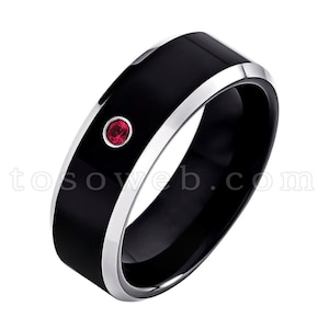 May include: A black tungsten carbide ring with a silver band and a single red gemstone.