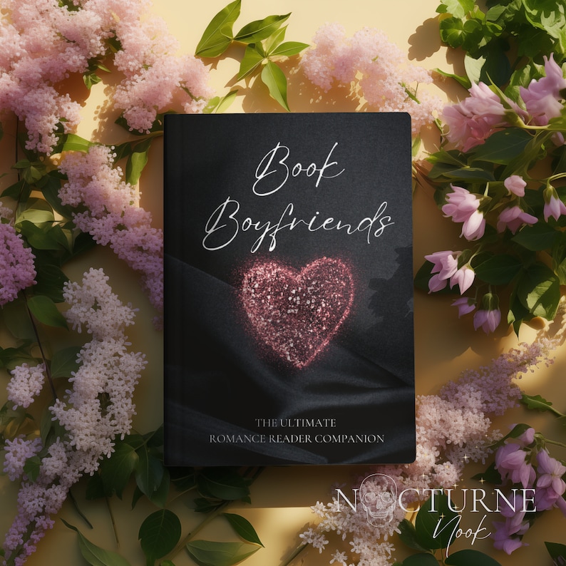 May include: A black book with the title "Book Boyfriends: The Ultimate Romance Reader Companion" and a pink glitter heart on the cover. The book is surrounded by pink flowers.