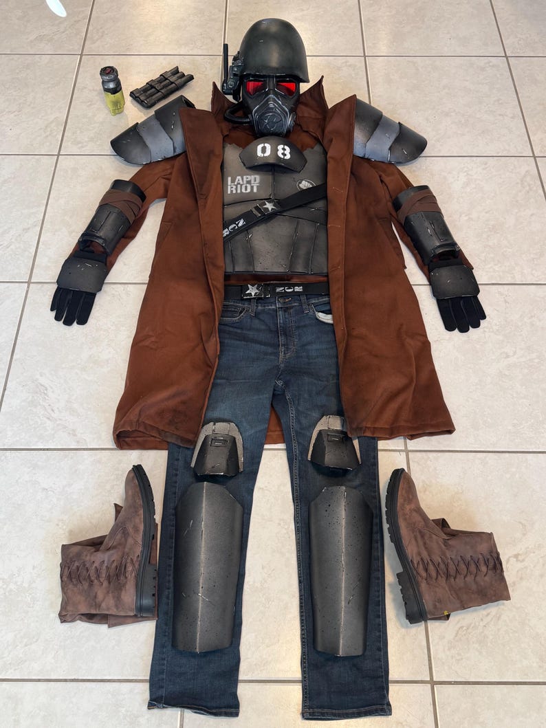K&ouml;nnte beinhalten: Ein komplettes Cosplay-Kost&uuml;m, das auf einem gefliesten Boden ausgebreitet ist. Das Kost&uuml;m umfasst einen braunen Duster-Mantel, einen schwarzen Helm mit rotem Visier, eine Brustplatte mit den Texten "08" und "LAPD RIOT", blaue Jeans und braune Stiefel. Zus&auml;tzliches Zubeh&ouml;r ist ebenfalls vorhanden.