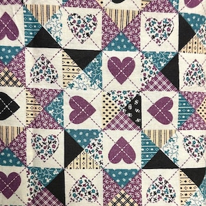 May include: A white fabric with a repeating pattern of purple, teal, black, and cream hearts. The hearts are arranged in a grid pattern and have different floral and geometric designs.