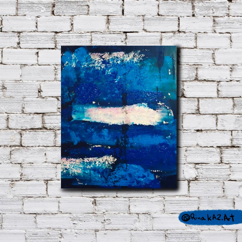 May include: Abstract painting with blue, white, and pink paint strokes on a canvas. The painting has a textured surface and a dark blue background.