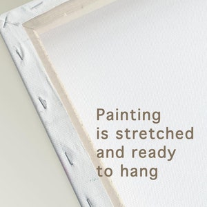 May include: Close-up of the edge of a stretched canvas painting. The canvas is white and the wooden frame is natural wood. The text "Painting is stretched and ready to hang" is printed on the canvas.