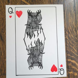 Puede incluir: Una ilustración en blanco y negro de la carta de la Reina de Corazones. La reina está representada como una criatura con una corona y un largo vestido fluido. La carta está rodeada por un borde rojo.