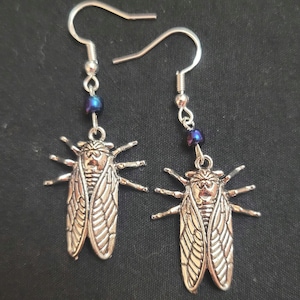 Silver cicada bug earrings with iridescent bead.
