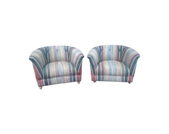 May include: A pair of striped armchairs with a colorful, watercolor-like pattern. The chairs have a rounded back and are upholstered in a soft fabric.