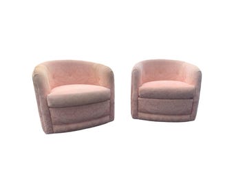May include: Two pink swivel chairs with a floral pattern upholstery.