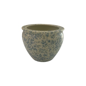 May include: A round, cream-colored ceramic planter with a blue floral pattern. The planter has a wide opening and a slightly flared rim. The floral design features delicate leaves and flowers, creating a classic, elegant look. Perfect for indoor or outdoor use.