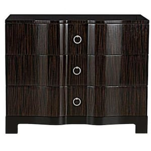 May include: A dark brown, three-drawer dresser with a curved front design. The dresser has a glossy finish with vertical wood grain. Each drawer features a circular, silver-toned handle. The dresser sits on a low, rectangular base.