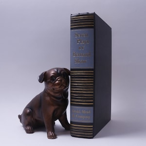 Pode incluir: Um livro preto de capa dura intitulado "Seven Plays by Bernard Shaw" com letras douradas e um design decorativo de listras douradas. O livro é publicado por Dodd, Mead & Company.