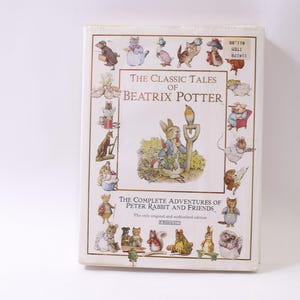 May include: A boxed set of "The Classic Tales of Beatrix Potter" featuring illustrations of Peter Rabbit and friends. The cover has a cream-colored background with various animal characters and text.