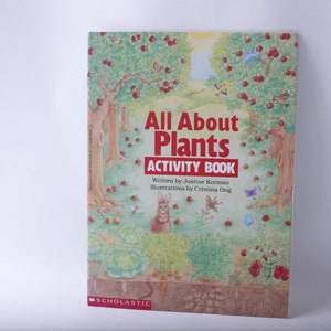 May include: A colorful book cover with a green, brown, and red illustration of a garden with trees, flowers, and a rabbit. The title of the book is "All About Plants Activity Book" with the author and illustrator listed below. The book is published by Scholastic.