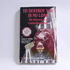 May include: A book titled "TO DESTROY YOU IS NO LOSS" with the subtitle "The Odyssey of a Cambodian Family." The cover features a portrait and text in red and white. The author is Joan D. Criddle. Includes an "Autographed Copy" sticker.
