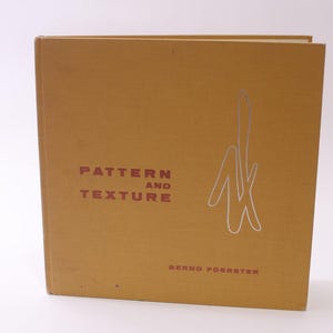 May include: A hardcover book titled "Pattern and Texture" by Bernd Foerster. The book has a mustard-yellow cover with the title and author's name in maroon. A silver abstract design is on the right side of the cover.