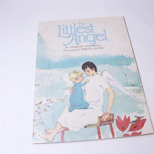 Pu&ograve; includere: Una copertina di libro vintage intitolata "The Littlest Angel" con illustrazioni di un angelo e un bambino. La copertina presenta uno sfondo di cielo azzurro chiaro con accenti floreali e di uccelli. L'angelo &egrave; raffigurato con ali bianche e un'aureola.