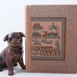 May include: A vintage book titled "Do and Dare" with a brown cover and a decorative border. The cover features illustrations of a ship, a train, a man on a bicycle, and other figures in a blue and green color scheme.