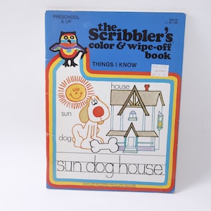 May include: A vintage wipe-off book for preschoolers and up, featuring a colorful illustration of a sun, dog, and house. The book is titled "The Scribbler's Color & Wipe-Off Book" and includes the words "Things I Know".