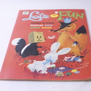 May include: A red book with the title "Let's o Fun" and the words "Things to Make Puzzles Dots Games Mazes". The cover features illustrations of a fox wearing a crown, a skunk, and a rabbit.