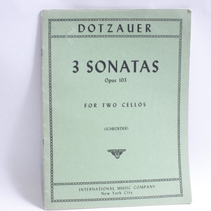 Puede incluir: Una cubierta verde para un libro de música titulado "DOTZAUER 3 SONATAS Opus 103 PARA DOS CHELOS (SCHROEDER) INTERNATIONAL MUSIC COMPANY New York City"