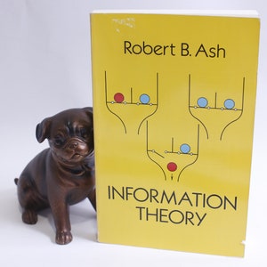 以下が含まれることがあります： 表紙に「INFORMATION THEORY」というタイトルと著者「Robert B. Ash」が印刷された黄色の本。表紙には、赤と青の円が線で結ばれた図も描かれている。