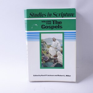 Può includere: Un libro verde e bianco intitolato "Studies in Scripture" con il sottotitolo "The Gospels" e il testo "Volume Five" sulla copertina. La copertina presenta anche un'illustrazione di Gesù che insegna a un gruppo di persone.