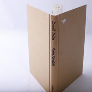 May include: A hardcover book titled "Death Notes" by Ruth Rendell. The book has a tan cover and spine with black lettering. The pages are visible at the top, and the book is open.