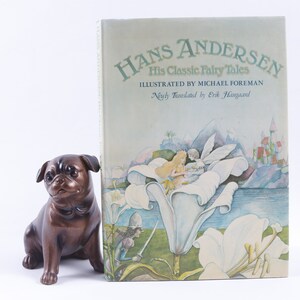 May include: A book titled "Hans Andersen His Classic Fairy Tales" illustrated by Michael Foreman. The cover features a watercolor illustration of a fairy and a woman sitting on a large white flower. The background shows a castle and a lake.