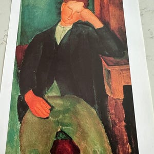 Puede incluir: Impresión de una pintura que representa una figura sentada con una mano apoyando su cabeza. La figura lleva una chaqueta negra, pantalones verdes y una camisa blanca con cuello. El fondo presenta tonos verdes y marrones.