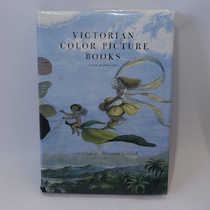 May include: A book cover with a blue background and a title that reads "Victorian Color Picture Books" with the author's name "written Jonathan Gotti" and a commentary by "Maurice Sendak". The cover features an illustration of two fairies flying in the sky.