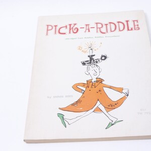 Könnte beinhalten: Ein Buch mit dem Titel "Pick-A-Riddle" mit einer Cartoon-Illustration einer Person, die eine Kerze auf dem Kopf trägt. Das Buch ist von Ennis Rees.