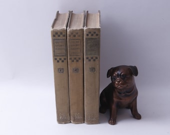 May include: Three vintage hardback books titled "Short Story Classics" with a bronze dog figurine bookend. The books are numbered 1, 2, and 3.