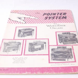 May include: Vintage booklet titled "The Pointer System for Wurlitzer Organs." The cover features a hand pointing, with illustrations of organs and text in pink and black. The booklet is slightly worn.