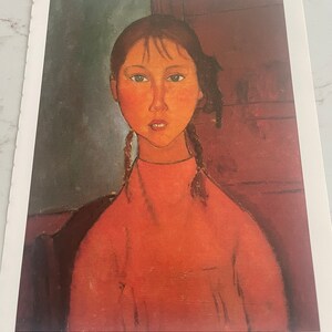 May include: A painting of a young girl with long brown hair in braids, wearing a red sweater. The girl has a serious expression on her face and is looking directly at the viewer. The background is a dark green and brown.