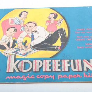 May include: A vintage blue and yellow book with the title "KOIPIEIEIFUIN magic copy paper kit" and a cartoon illustration of a family using the kit to create cartoons. The book cover also includes the text "COPIES PICTURES from any newspaper. New easy way to CREATE CARTOONS 5000 funny combinations."
