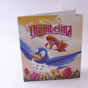 May include: A yellow, blue, and pink children's book cover with the title "Good Times Storybook Classic: Thumbelina". The cover features an illustration of a small girl with red hair riding on a blue bird.