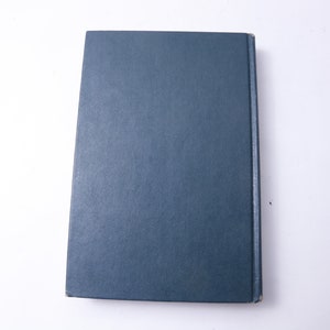May include: A dark blue hardcover book with a plain cover.