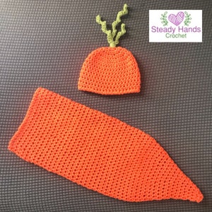 May include: A crocheted carrot costume for a baby, featuring a hat with green leafy top and a long, orange body.
